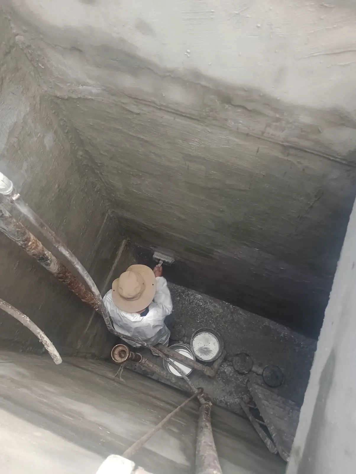 Interior de cisterna de condomínio durante limpeza pesada, risco sanitário real